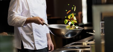 Gemüse wird in einer Wok-Pfanne geschwenkt