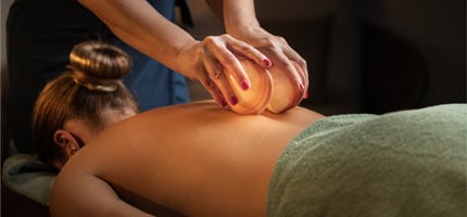 Wellnessmasseurin massiert den Rücken einer Frau